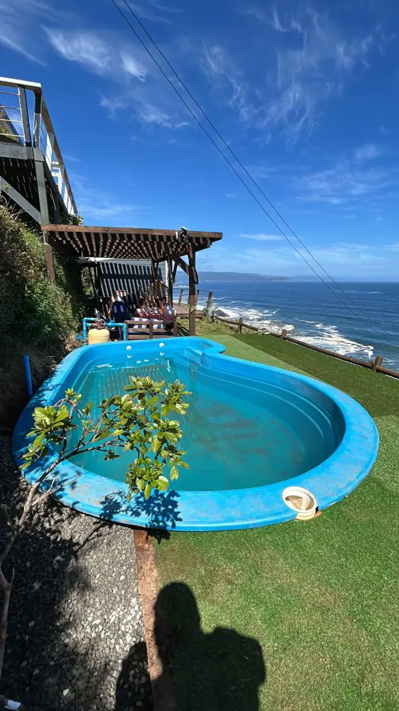 Piscina y pérgola con vista a la costa